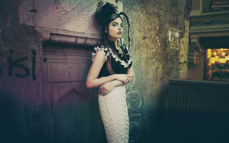 woman in vintage dress against stone wall