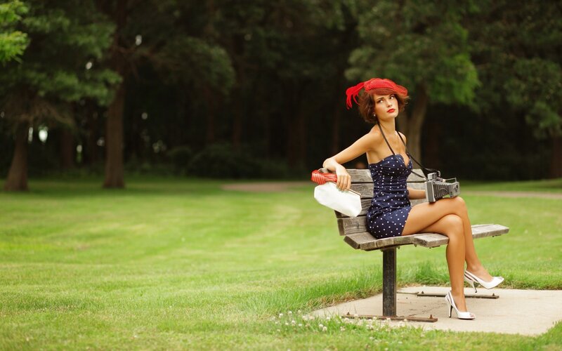 Woman in vintage dress on park bench