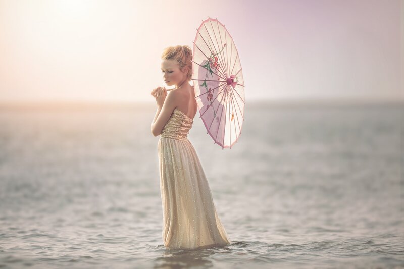 Woman in Water Holding Umbrella