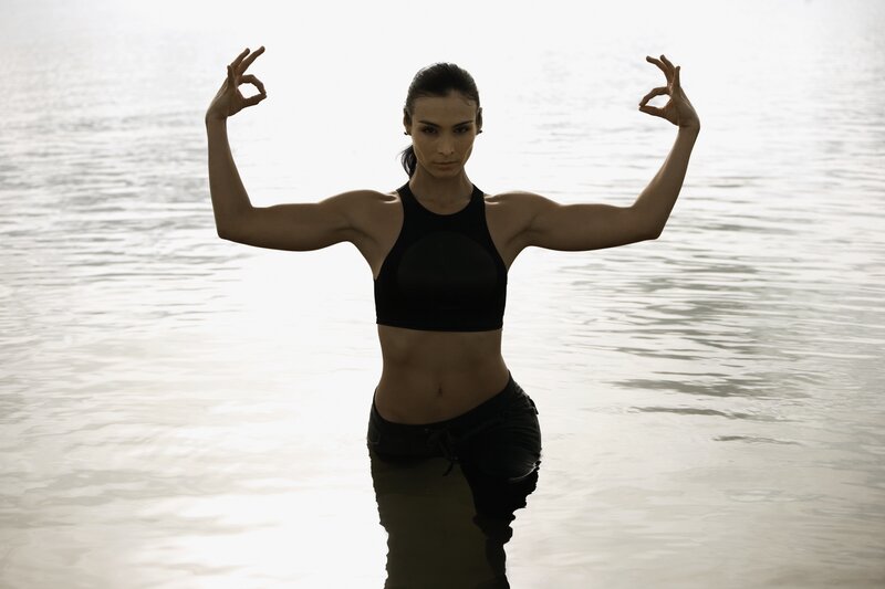 woman in water making hand gesture