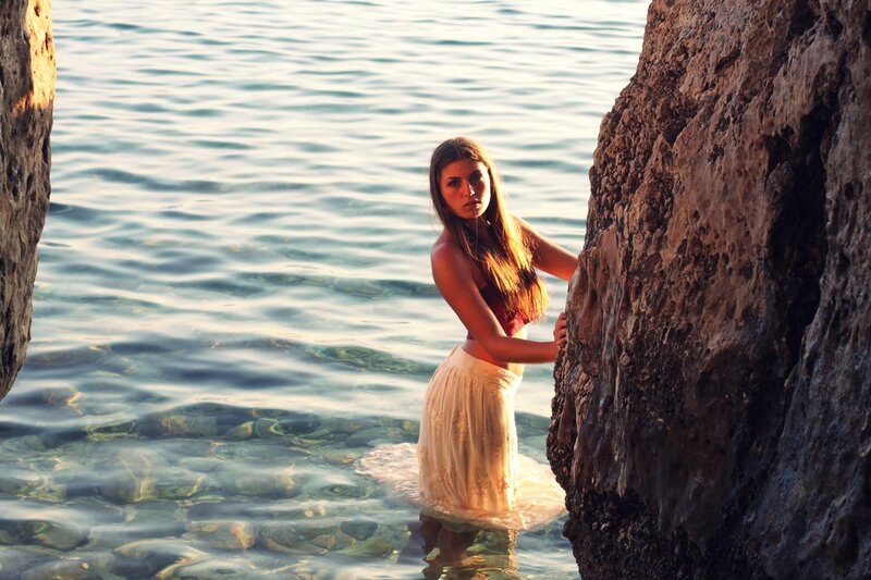 woman in water near rocks