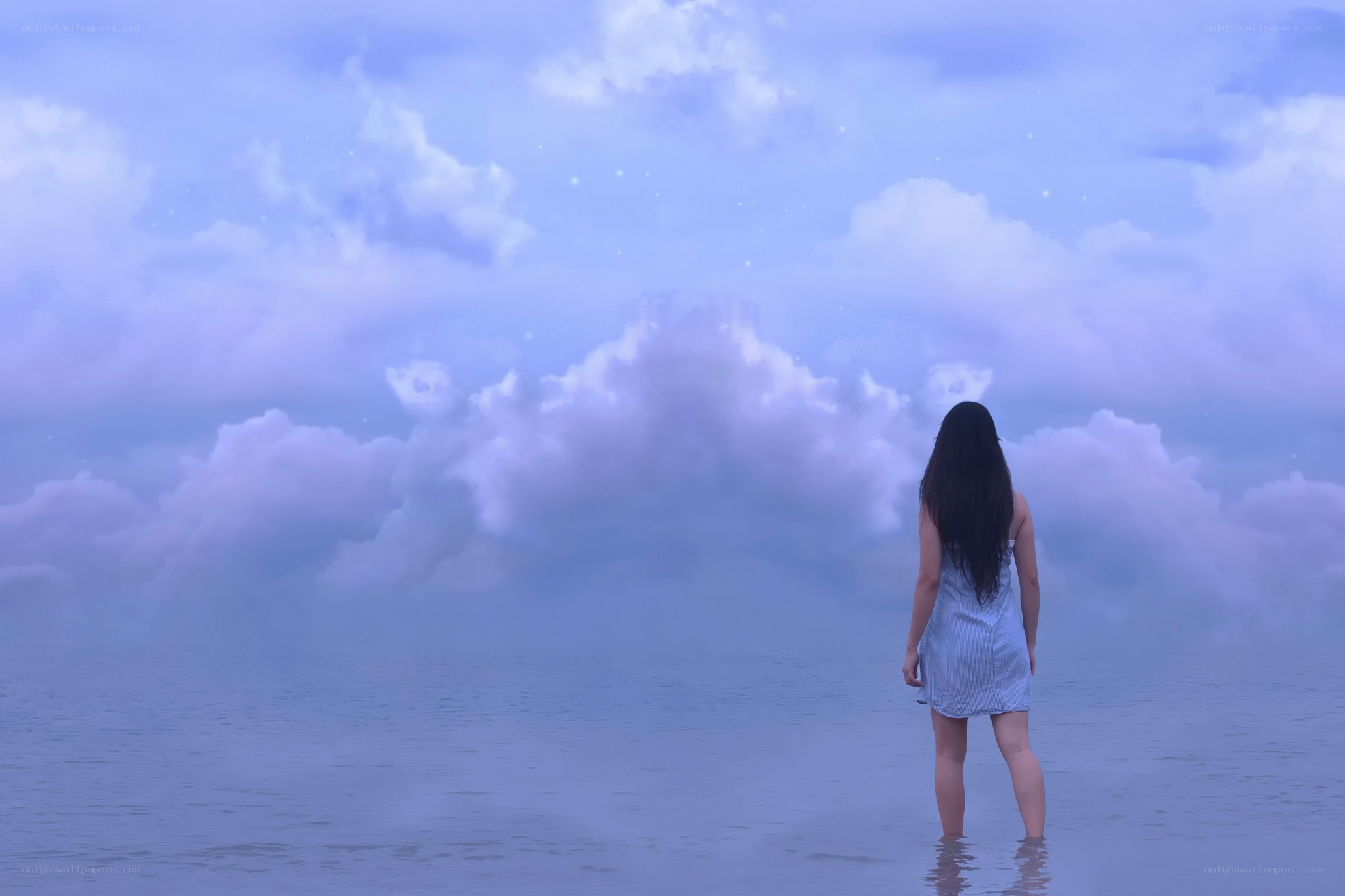 Woman in water under cloudy sky