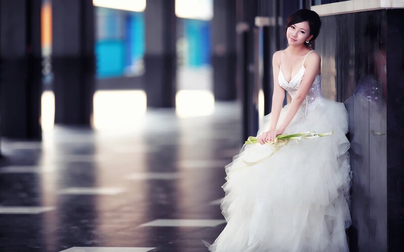 woman in wedding dress holding flowers