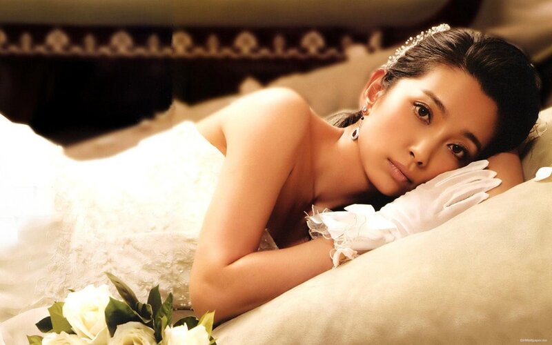 woman in wedding dress lying on bed