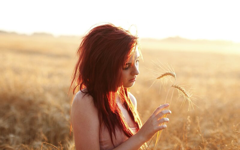 woman in wheat field at sunset