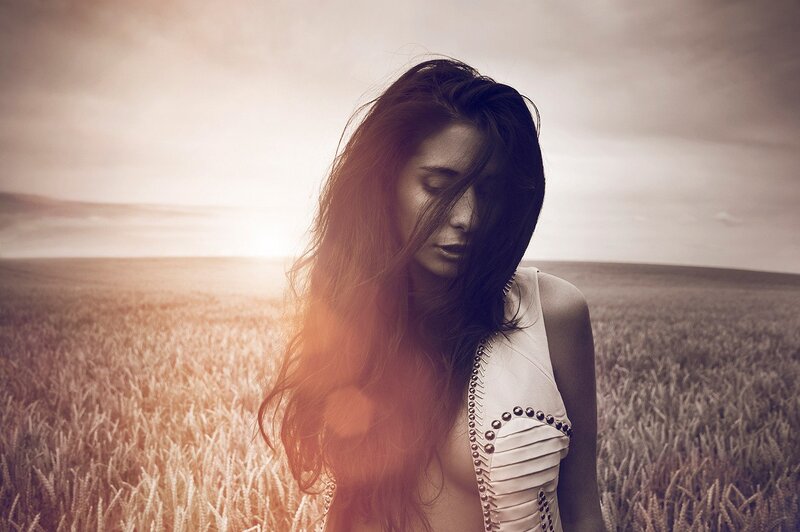 woman in wheat field at sunset