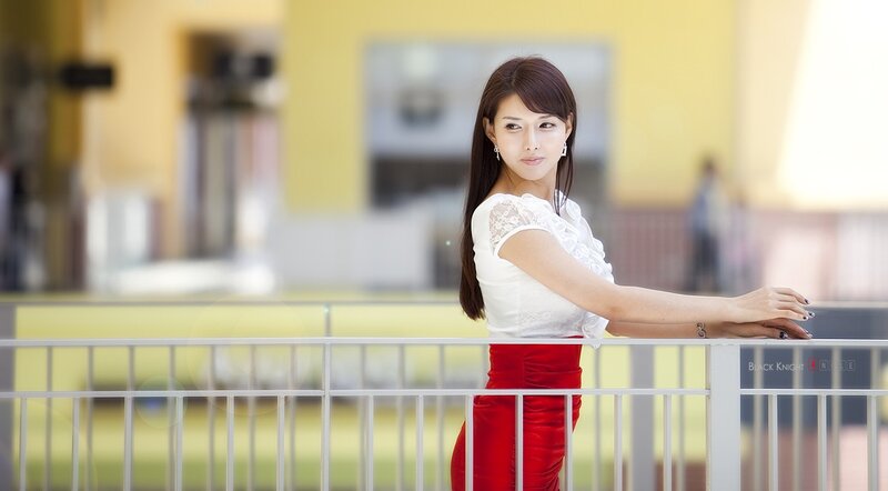 woman in white and red standing by railing