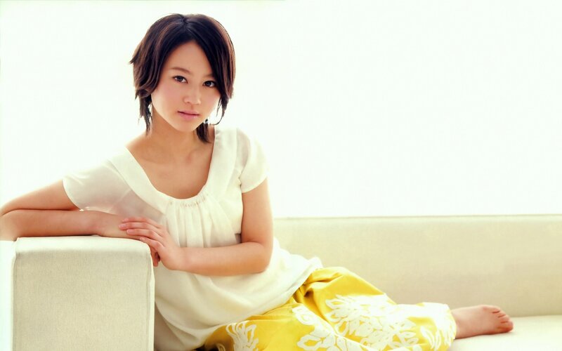 woman in white and yellow sitting on sofa