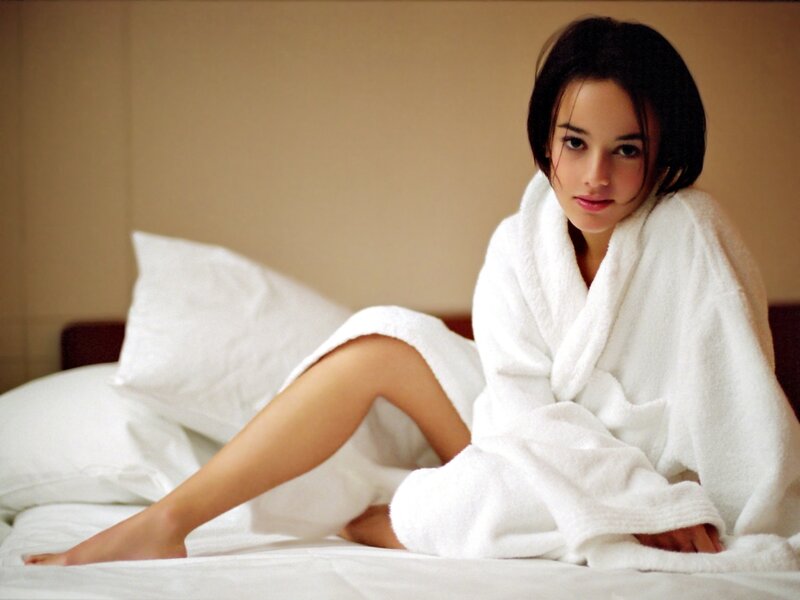 woman in white bathrobe on bed