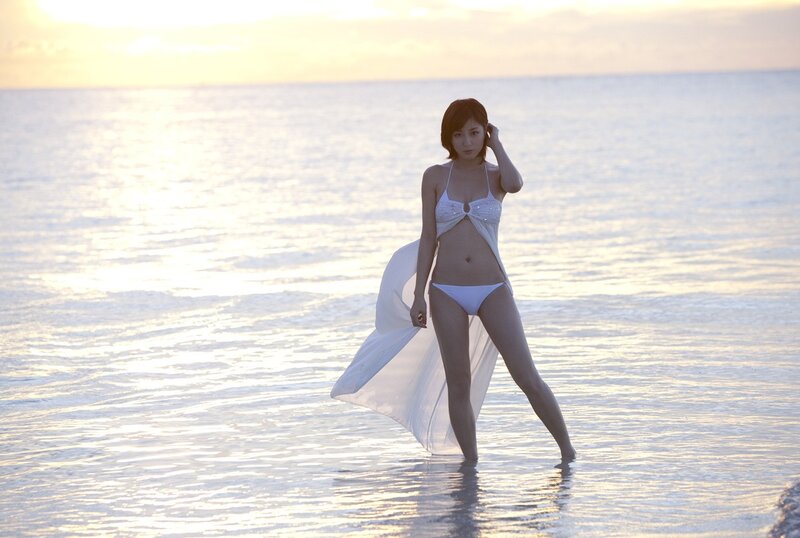Woman in white bikini at sunset