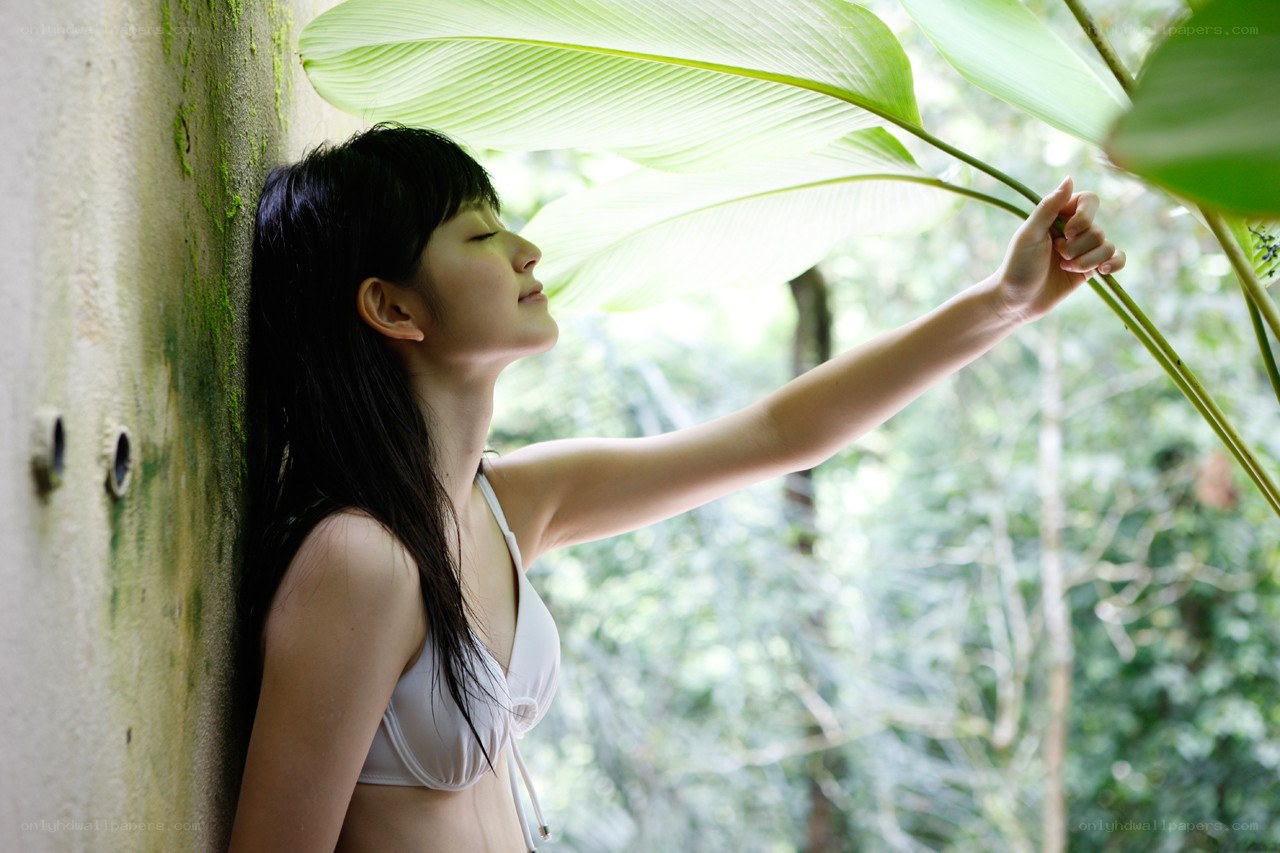 woman in white bikini touching leaf
