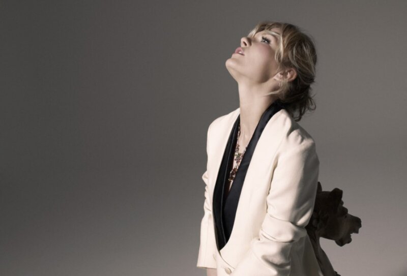 woman in white blazer looking up