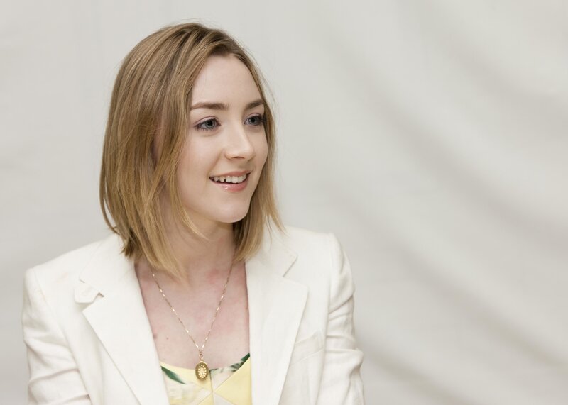 woman in white blazer smiling