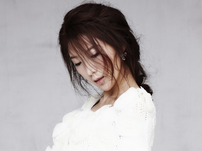 woman in white blouse looking down