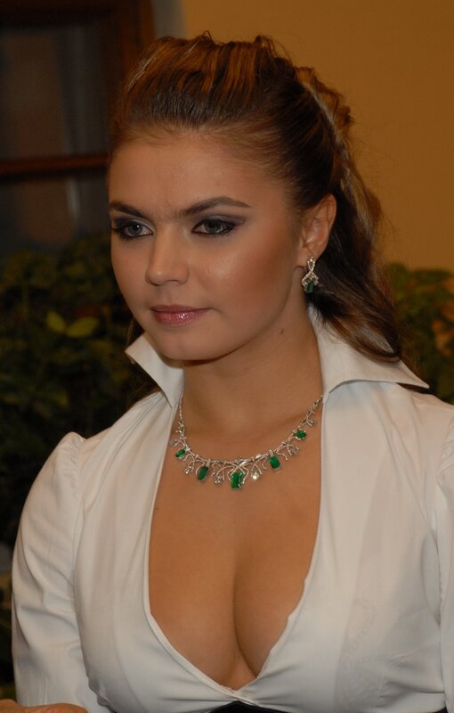 woman in white blouse with green jewelry