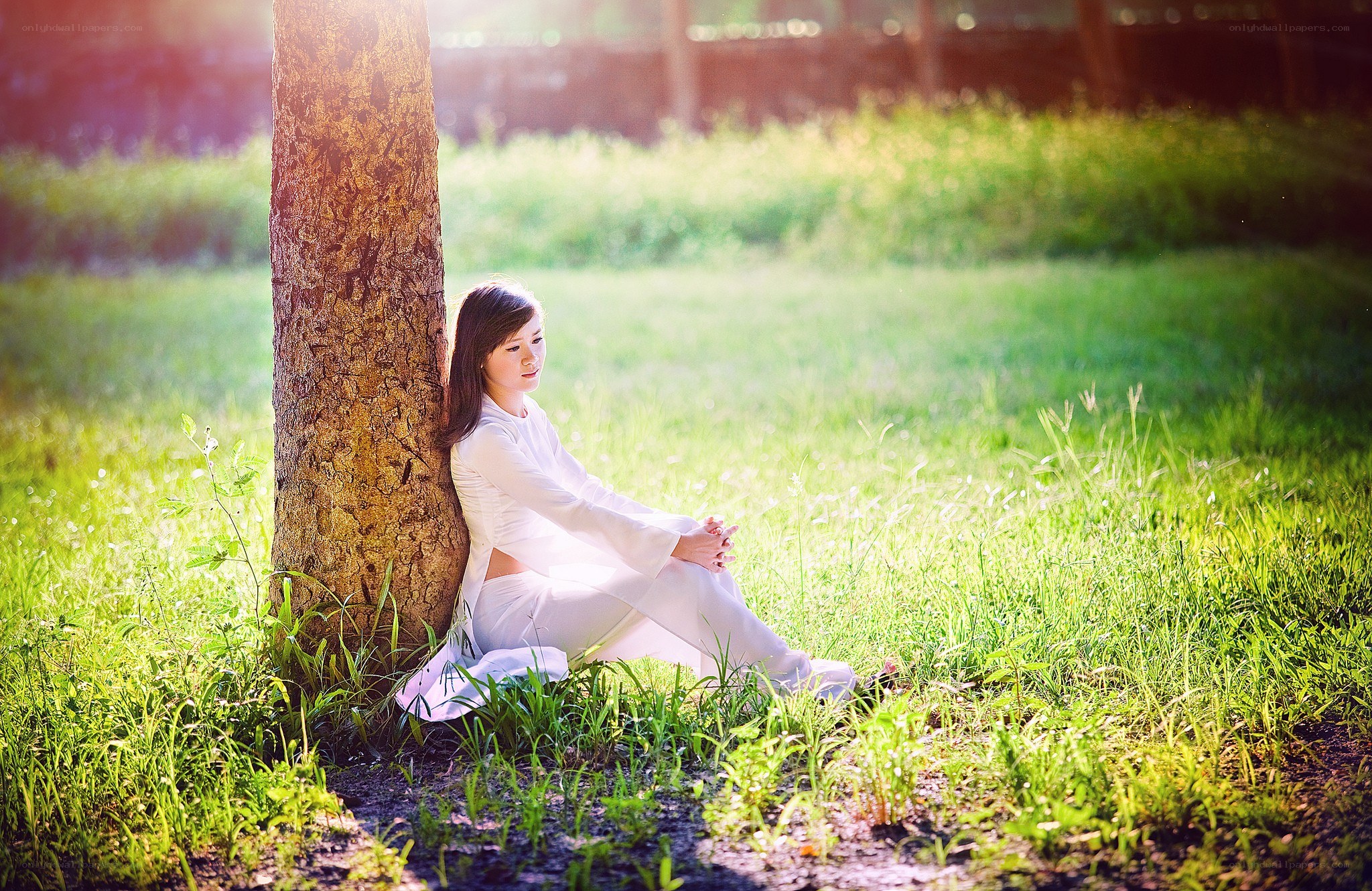 Woman in white by a tree