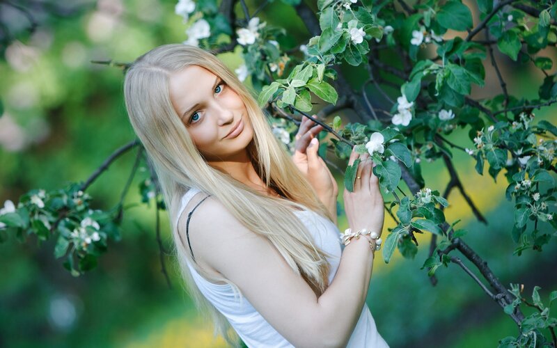 woman in white by blossoming tree