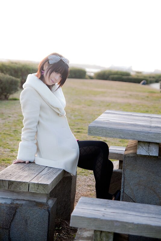 Woman in white coat at picnic table