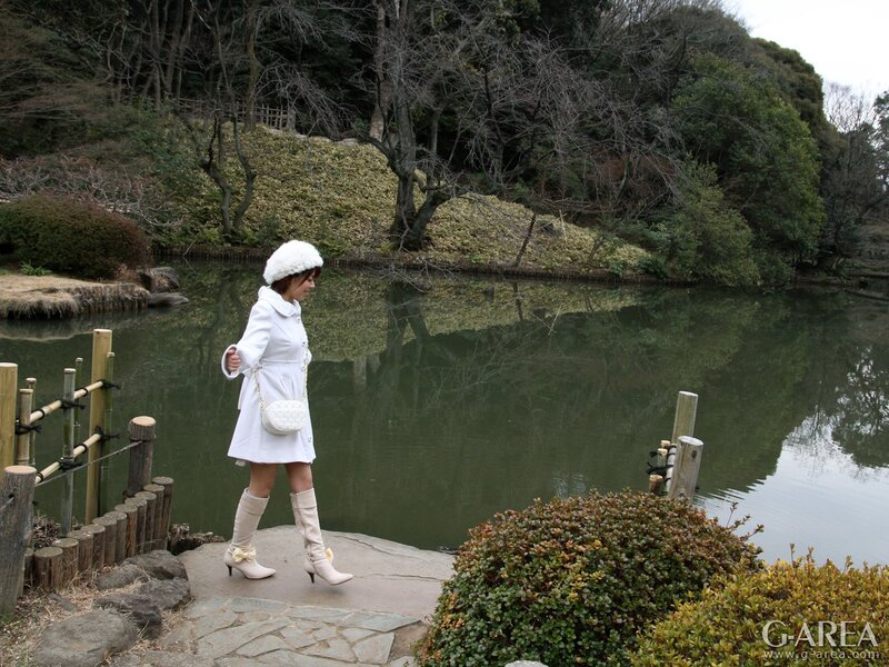 Woman in white coat by pond