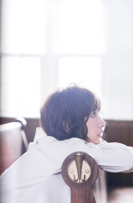 woman in white coat by window