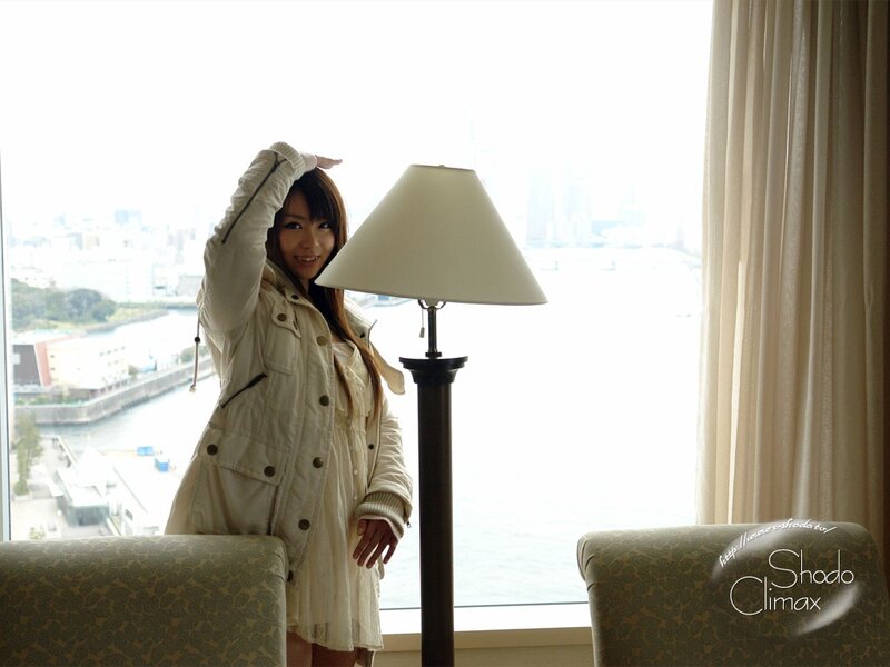 woman in white coat by window