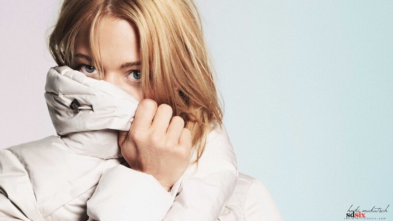 woman in white coat covering face