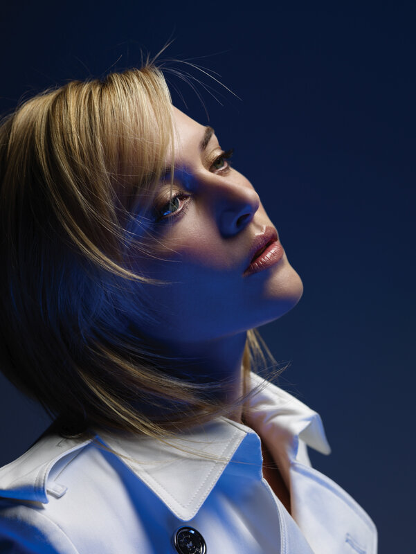 woman in white coat looking up