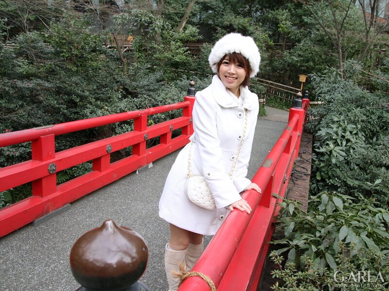 Woman in white coat on red bridge