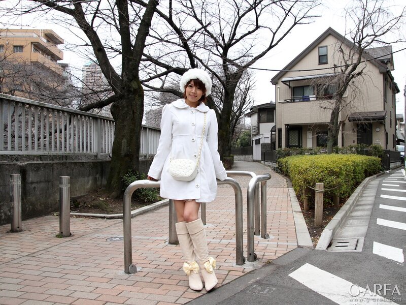 Woman in white coat on sidewalk