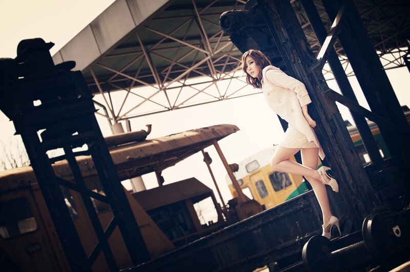 woman in white coat on train tracks