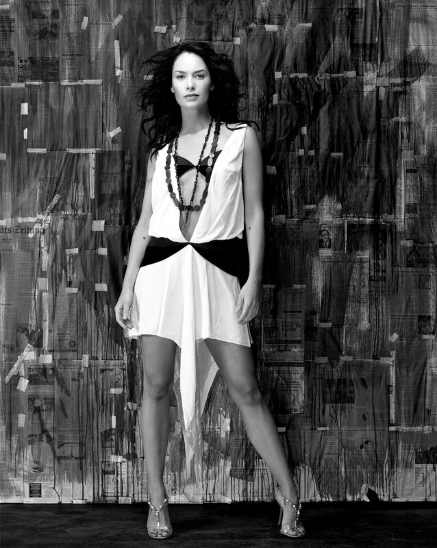 Woman in white dress against newspaper wall