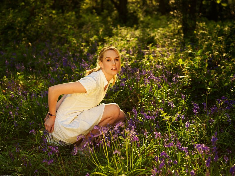 Woman in white dress among bluebells