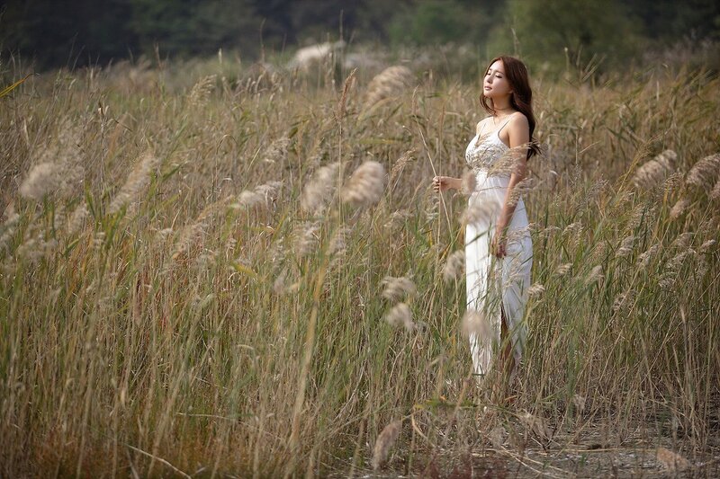 Woman in white dress among reeds