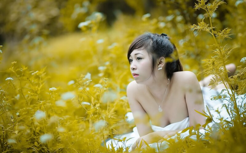 woman in white dress among yellow flowers