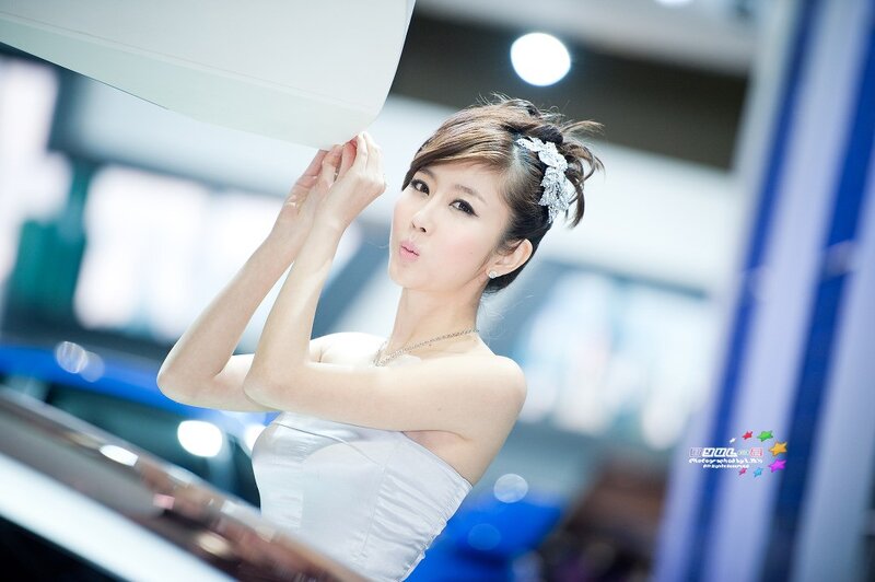 woman in white dress at auto show