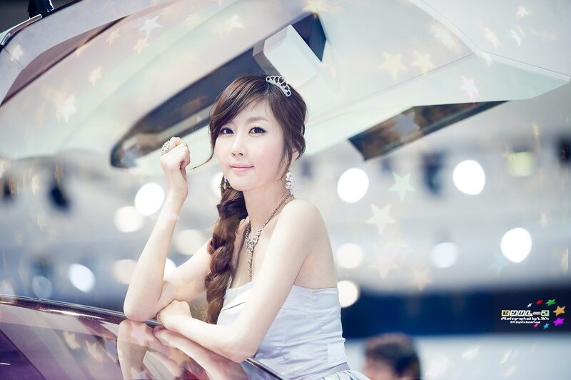 woman in white dress at auto show
