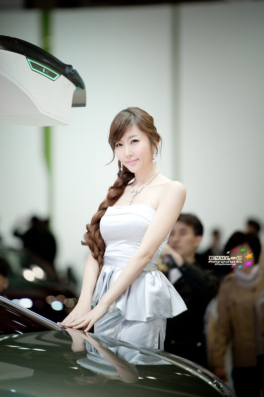 woman in white dress at auto show