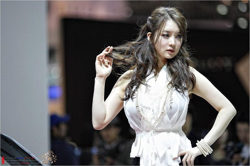 Woman in white dress at auto show