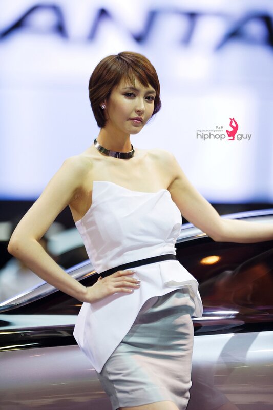 Woman in white dress at auto show
