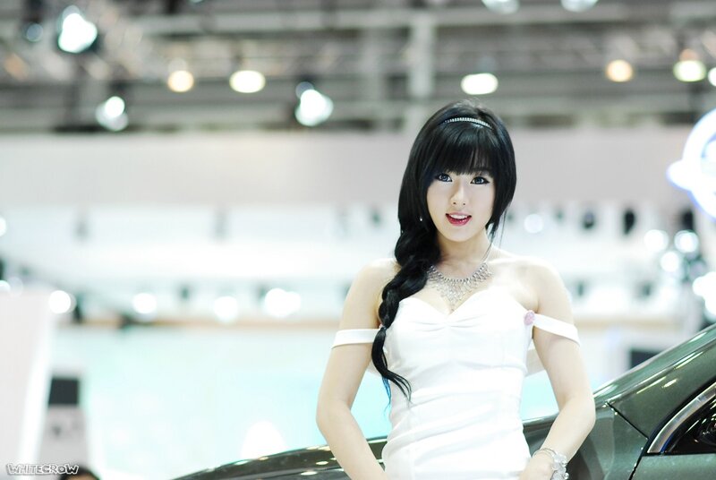 Woman in white dress at auto show