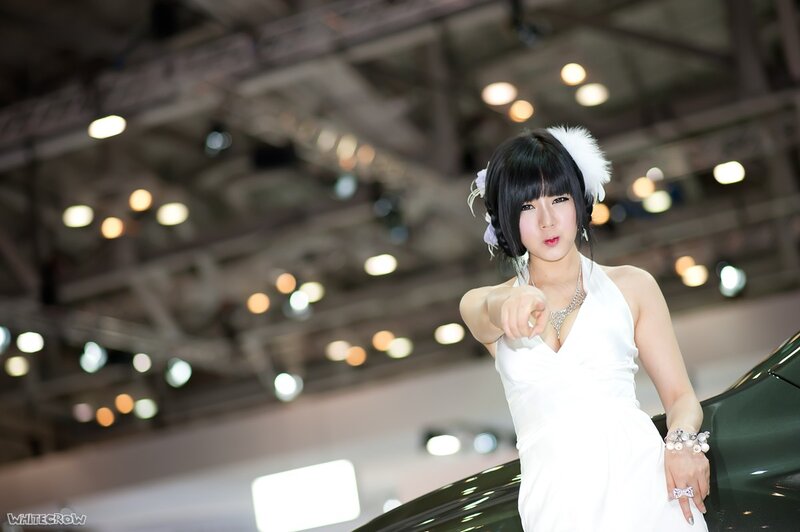Woman in white dress at auto show