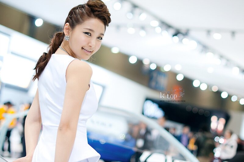 woman in white dress at auto show