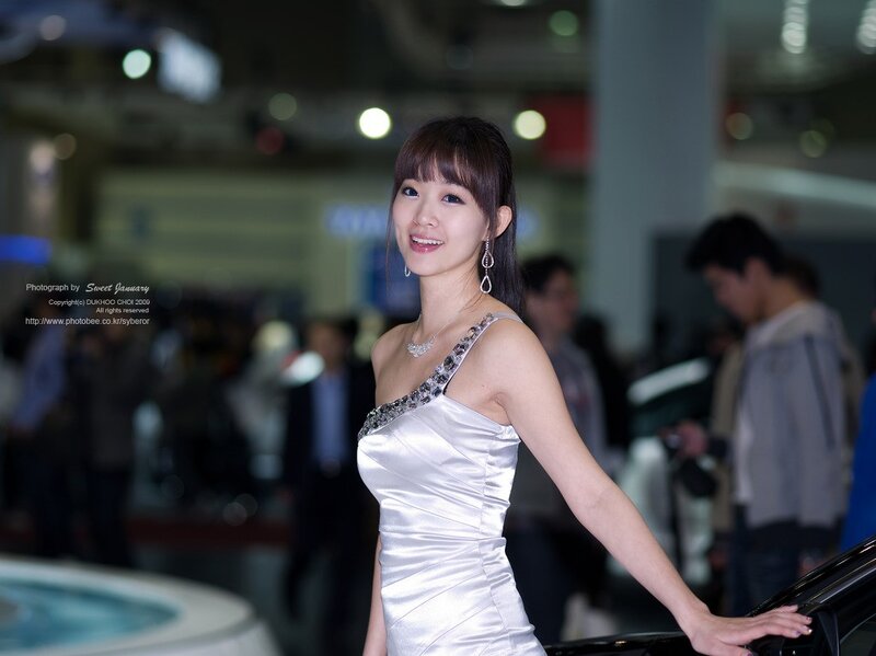 Woman in white dress at auto show
