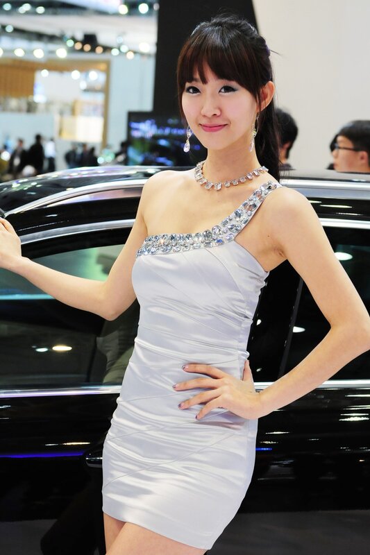 Woman in white dress at car show