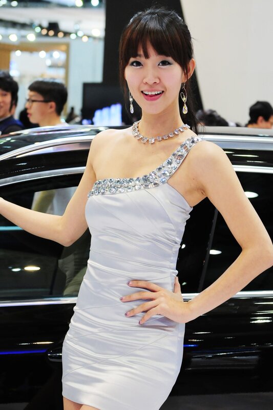 Woman in white dress at car show