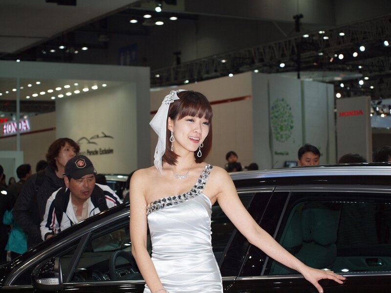 Woman in white dress at car show