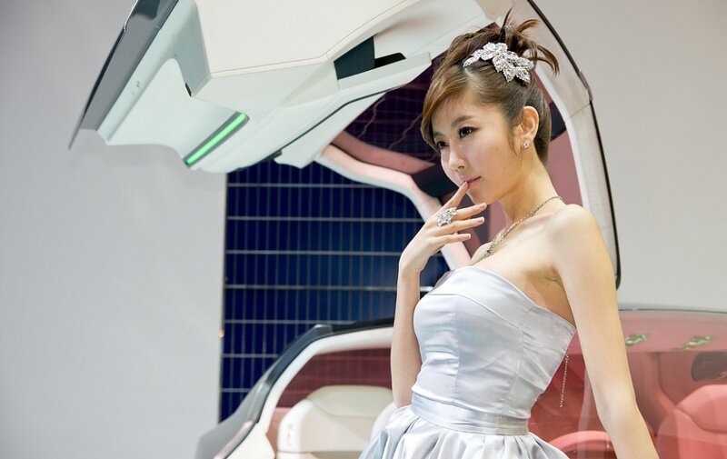 Woman in white dress at car show