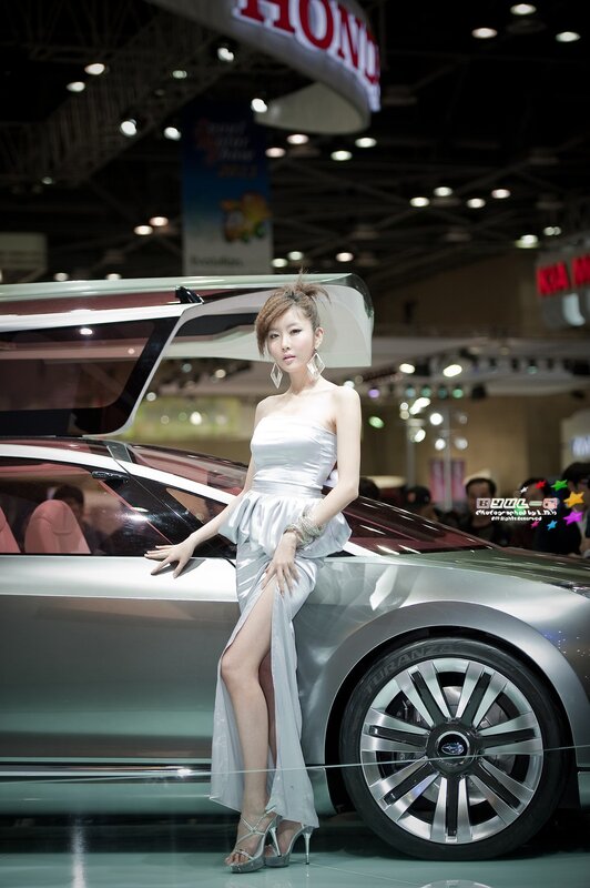 Woman in white dress at car show