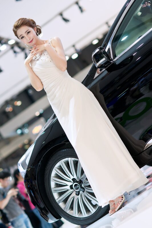 Woman in white dress at car show