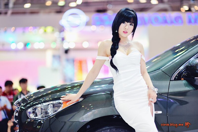 Woman in white dress at car show